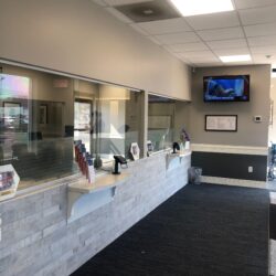 Receptionist beind long counter with glass guards