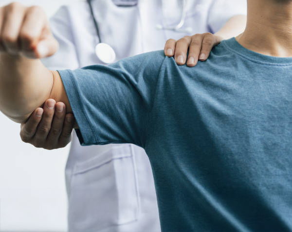 A man with shoulder pain goes to the doctor, The doctor diagnoses the patient's arm pain and shoulder pain. Concept of physical therapy and rehabilitation.